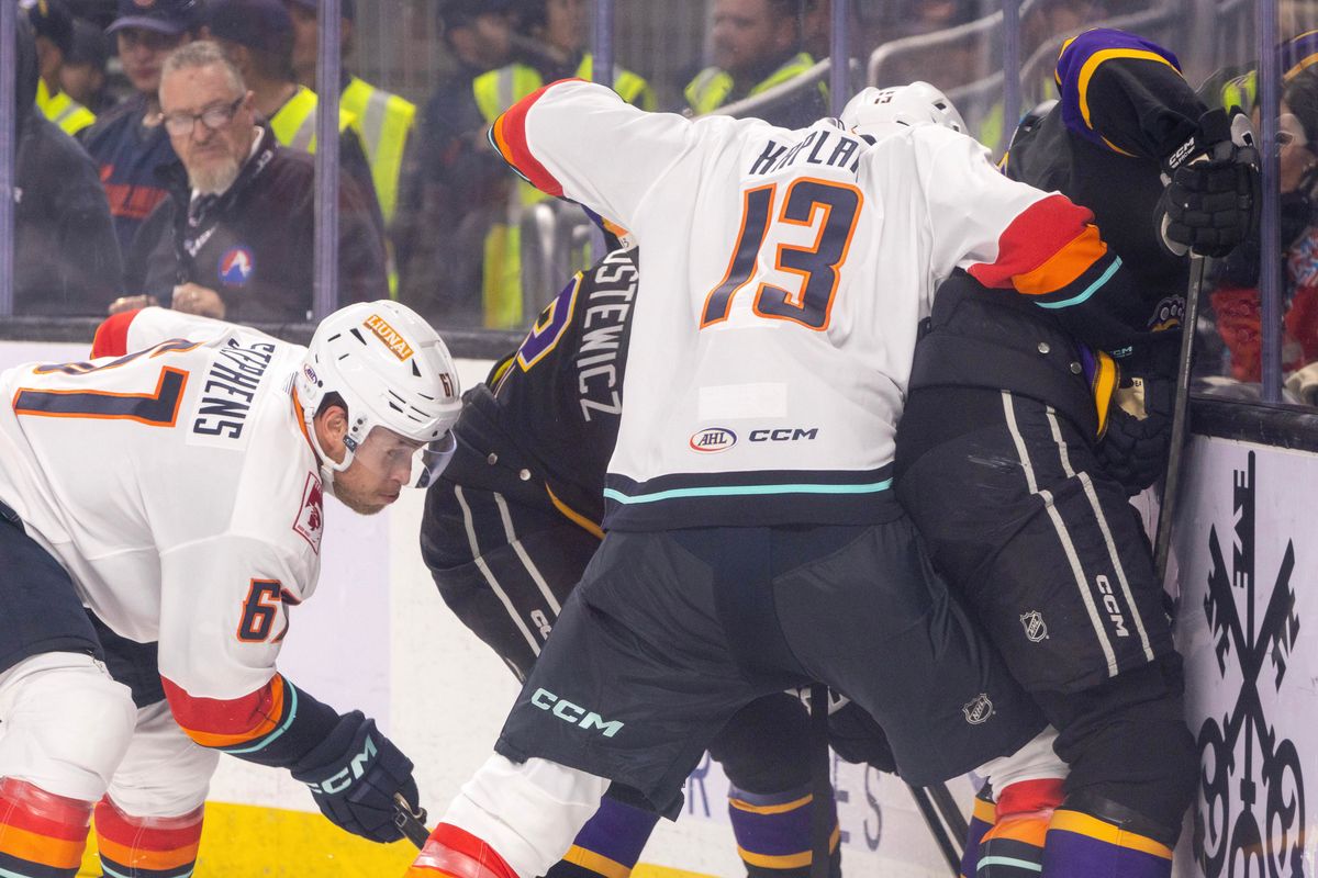 Coachella Valley Firebirds defenseman Lleyton Moore (13) checks an Ontario Reign player against the boards during an AHL hockey game, Sunday, October 11, 2026, in Palm Desert, Calif.