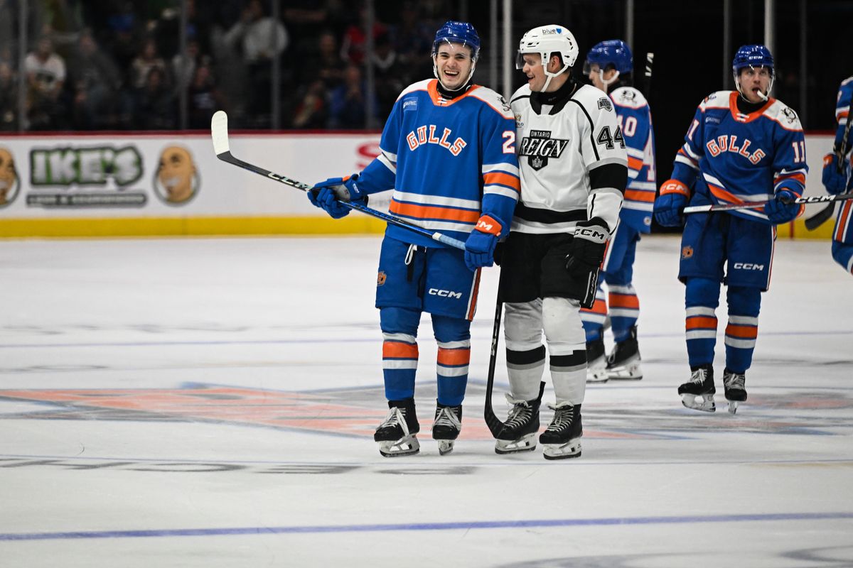 Ontario Reign forward Arthur Kaliyev (44) and San Diego Gulls right winger Jaxsen Wiebe (23) share a laugh before a faceoff  during an AHL hockey game, Friday, December 27, 2024 in San Diego, Calif.