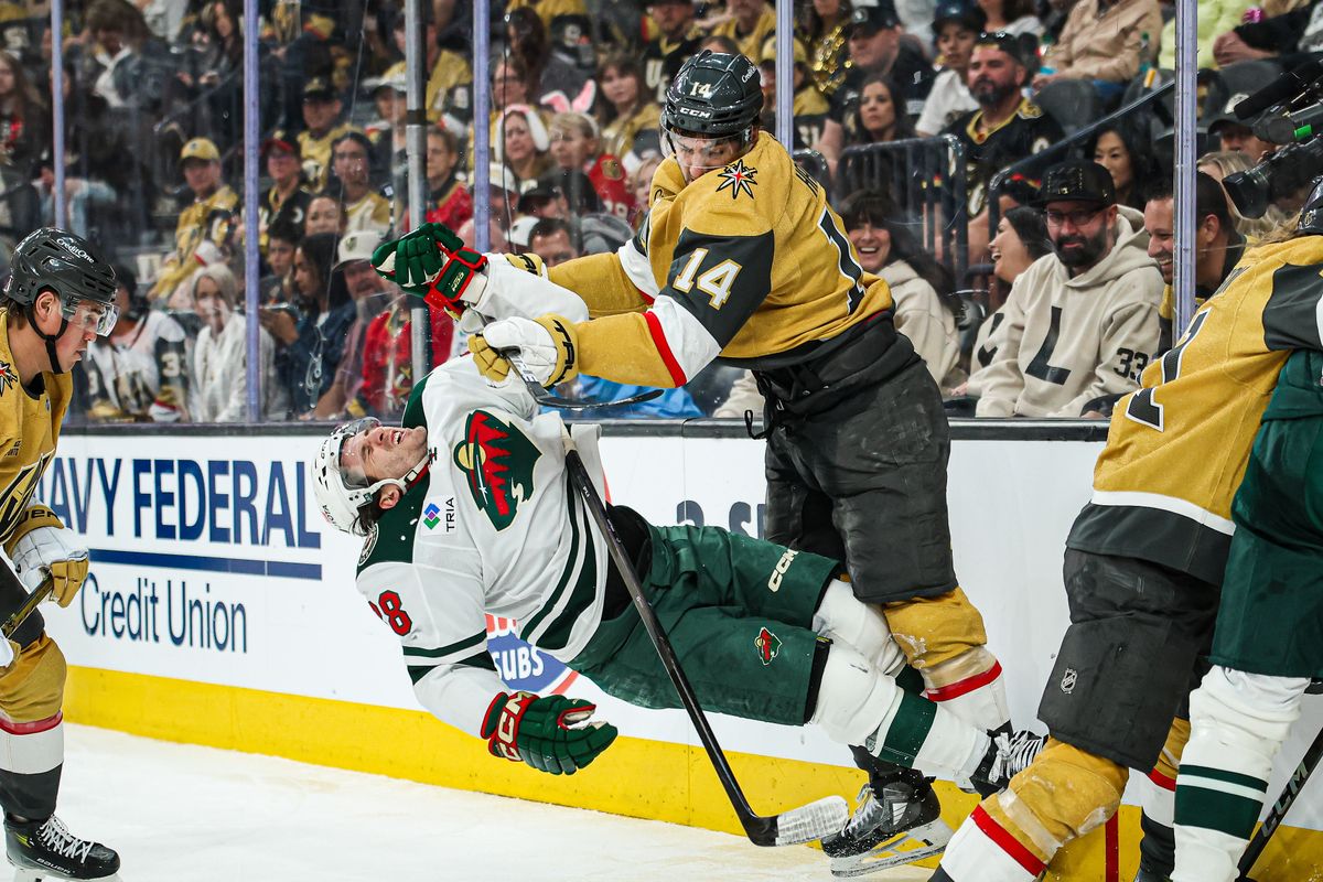Vegas Golden Knights D Nicolas Hague (14) pushes over Minnesota Wild F Ryan Hartman (38) during an NHL playoff game on Sunday April 20, 2025, at T-Mobile Arena.