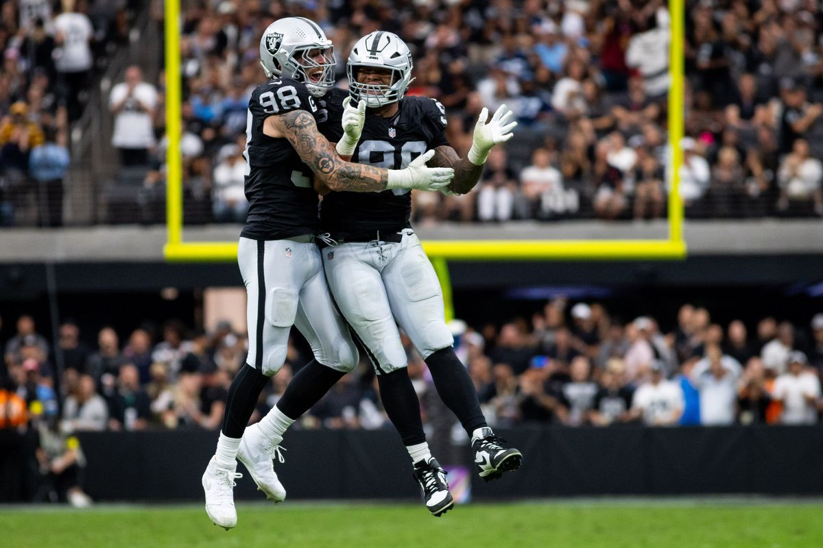 Las Vegas Raiders defensive end Maxx Crosby (98) and defensive tackle Jonah Laulu (96) jump in celebration after the Raiders intercepted the ball during a NFL game between the Las Vegas Raiders and the Tennessee Titans, Sunday October 12, 2025 in Las Vegas, Nev.
