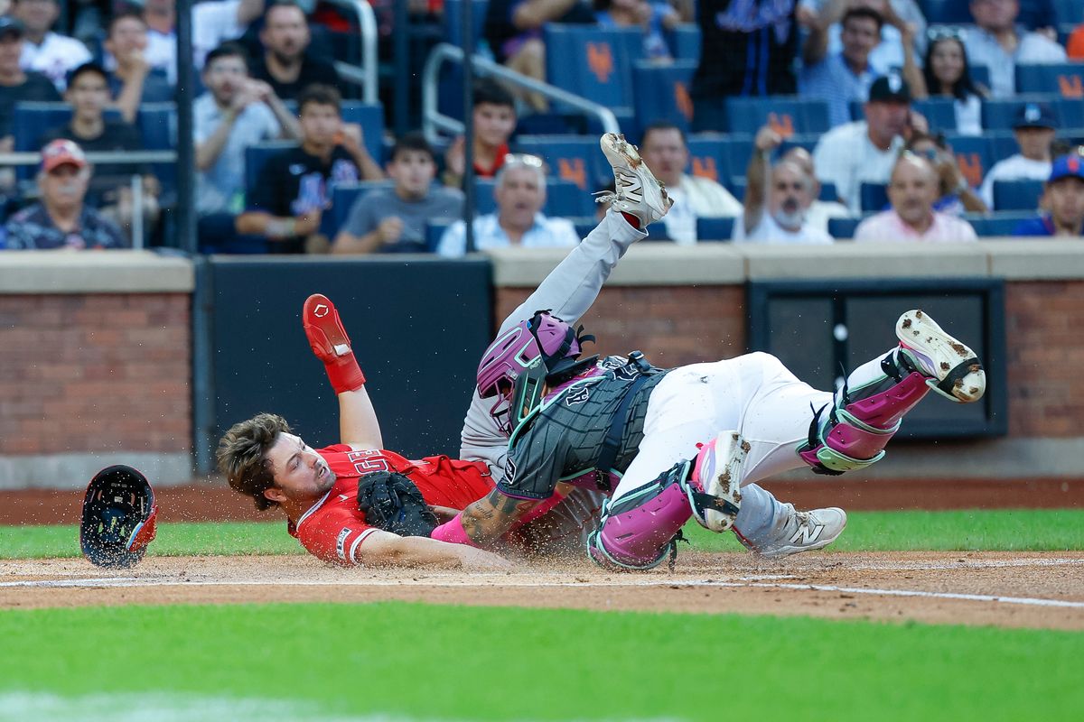Nolan Schanuel #18 of the Los Angeles Angels is tagged out at home plate by Francisco Alvarez #4 of the New York Mets at Citi Field on July 22, 2025 in New York City.