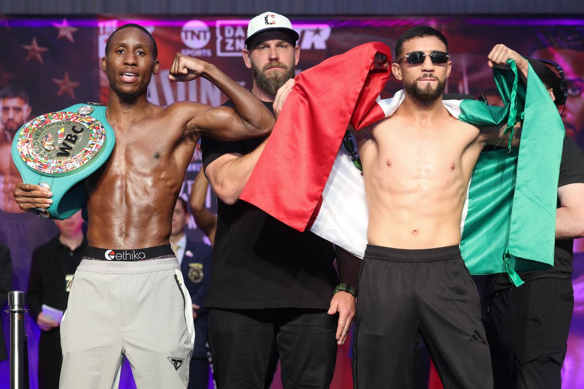 Bruce Carrington and Rene Palacios pose after Friday's weigh-in ahead of their WBC featherweight title fight Saturday in Cleveland.