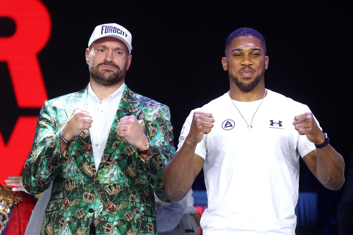 Tyson Fury, left, and Anthony Joshua, right, pose with raised fists during Wednesday's press conference at Olympia in London. Tyson Fury, left, and Anthony Joshua, right, pose with raised fists during Wednesday's press conference at Olympia in London.