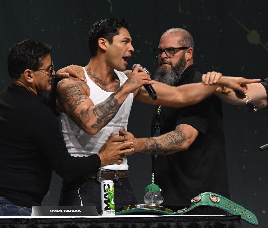 Ryan Garcia is held back after grabbing the microphone during the Fanatics Fest press conference.