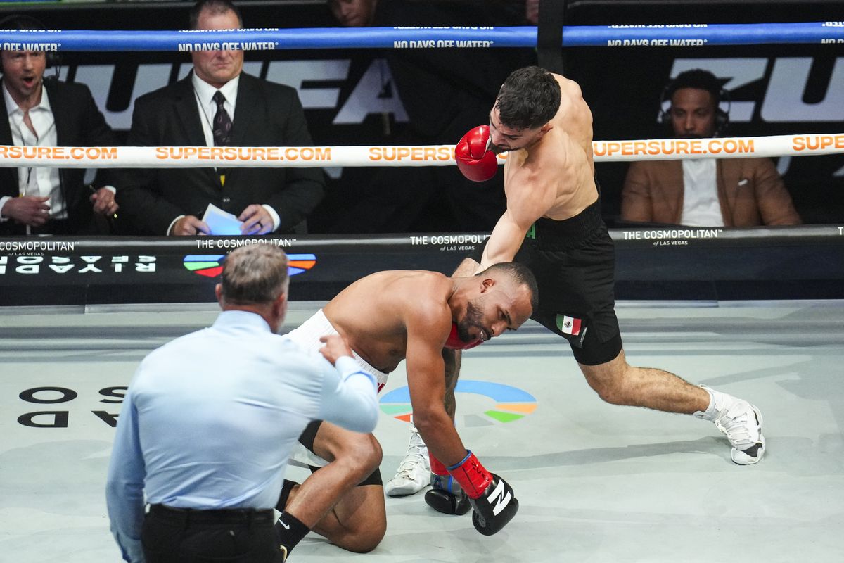 Referee Thomas Taylor moves in to separate Valenzuela and De Los Santos moments after the knockdown. Referee Thomas Taylor moves in to separate Valenzuela and De Los Santos moments after the knockdown.