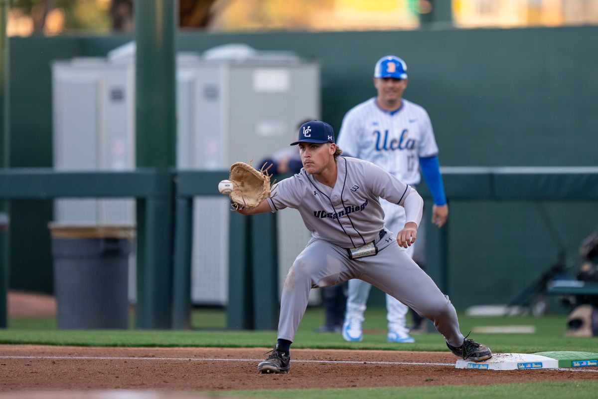 UC San Diego infielder, Gabe Camacho (34) catching a passed ball for an out at first base during a NCAA baseball game against UC San Diego on February 13, 2026 at Jackie Robinson Stadium in Los Angeles, CA.