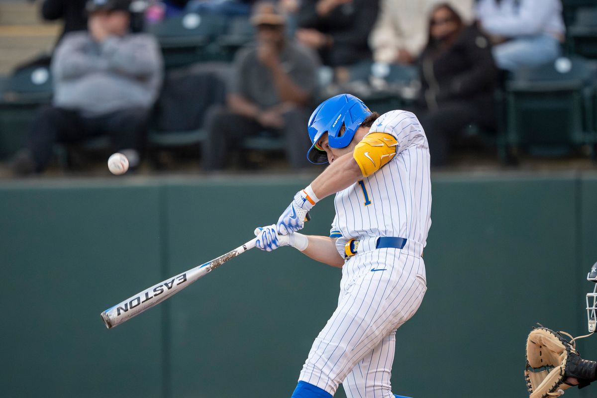 UCLA infielder, Roch Cholowsky (1) at bat, mid hit during a NCAA baseball game against UC San Diego on February 13, 2026 at Jackie Robinson Stadium in Los Angeles, CA.