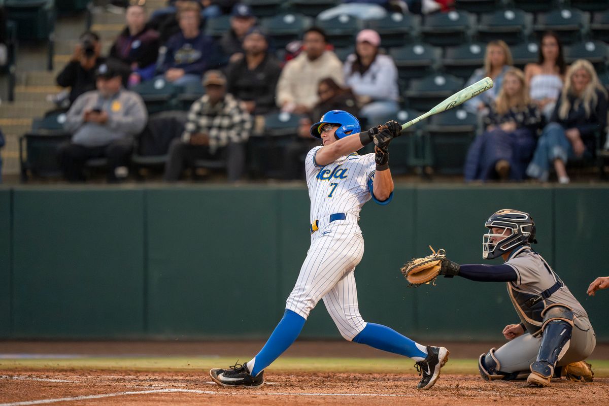 UCLA infielder, Roman Martin (7), at bat, mid-hit during a NCAA baseball game against UC San Diego on February 13, 2026 at Jackie Robinson Stadium in Los Angeles, CA.