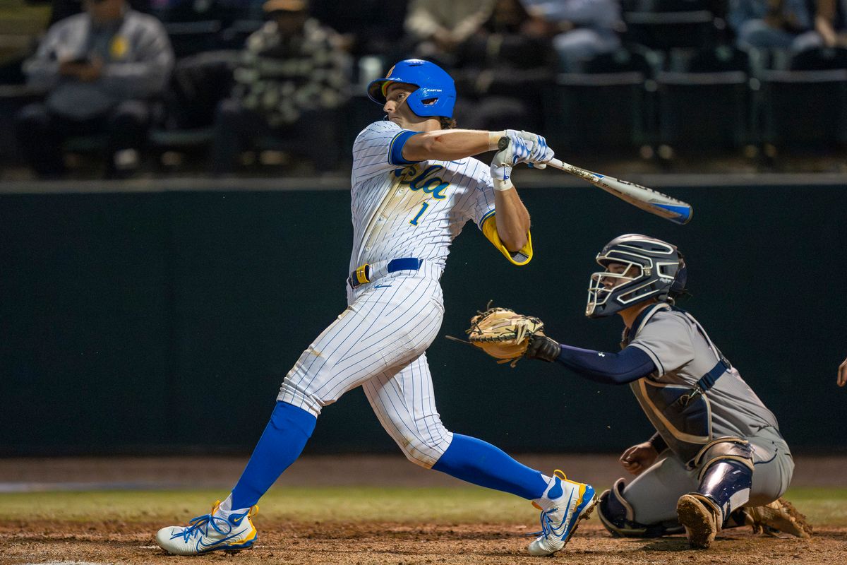UCLA infielder, Roch Cholowsky (1) at bat, mid-hit during a NCAA baseball game against UC San Diego on February 13, 2026 at Jackie Robinson Stadium in Los Angeles, CA.