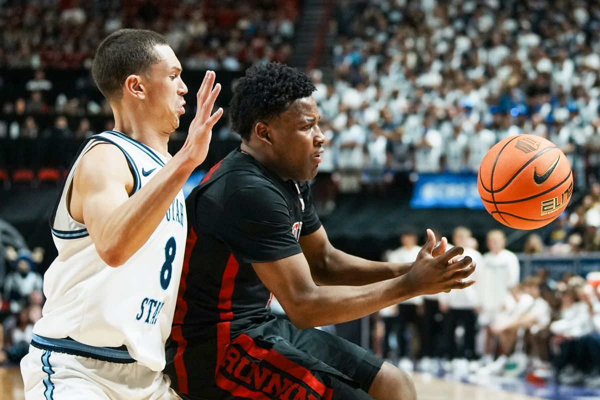 UNLV guard Issac Williamson (12) and Utah State Drake Allen (8) eye the ball after Williamson looses control of the ball over Zach Keller (32) during the second round of a Mountain West Championship tournament game between the UNLV and Utah State on Thursday March 12, 2026 in Las Vegas, Nev.