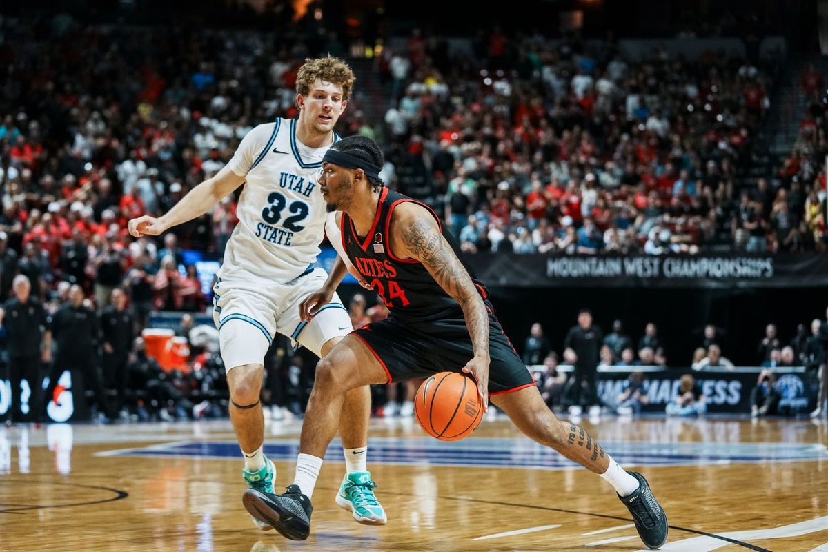 San Diego State Taj DeGourville (24) drives towards the basket while guarded by Utah State forward Zach Keller (32) during final Mountain West Championship tournament game between San Diego State and Utah State on Saturday March 14, 2026 in Las Vegas, Nev.