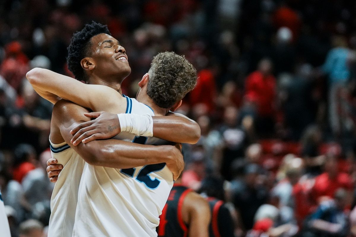 Garry Clark (11) and Mason Falslev (12) share a moment of embrace during Utah State's 73-62 win over San Diego State in the Mountain West Championship Game on Saturday, March 14, 2026 in Las Vegas, Nev.