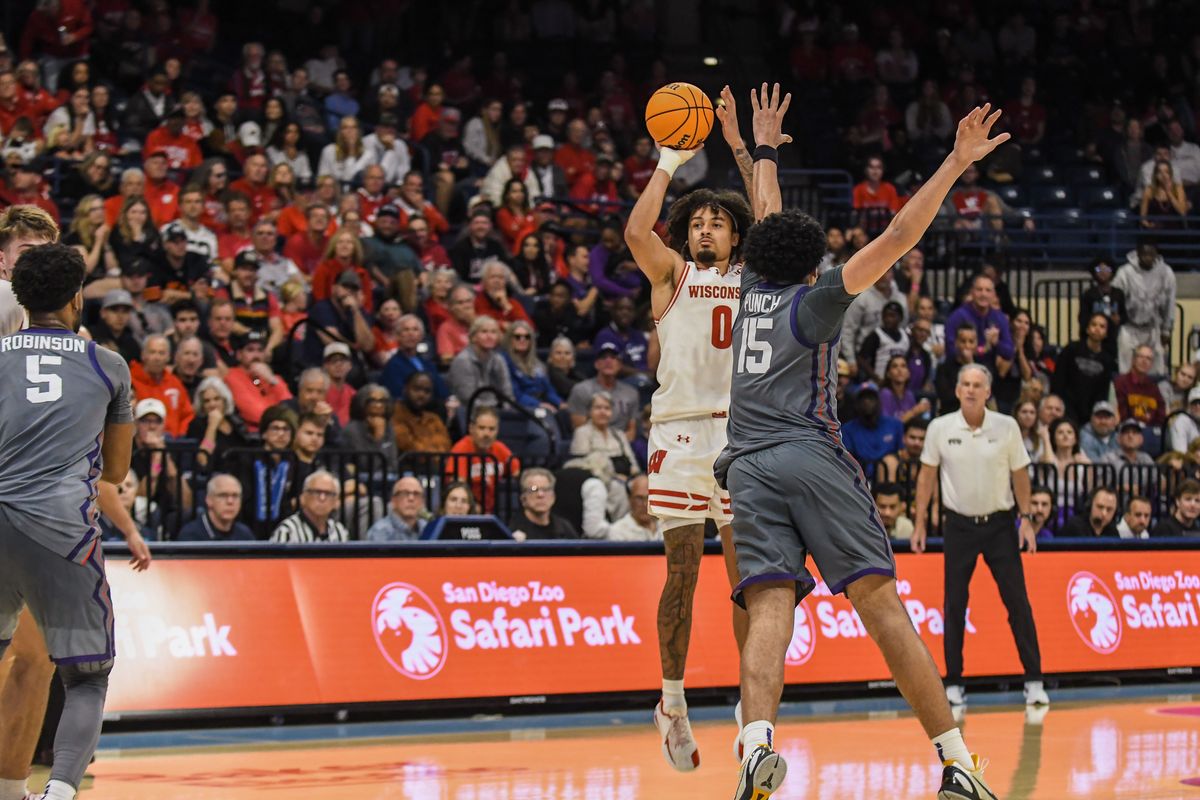 Wisconsin guard Braeden Carrington (0) shoots a three point shot over TCU forward David Punch (15) during an NCAA basketball  game against TCU, Friday November 28, 2025 in  San Diego, California.