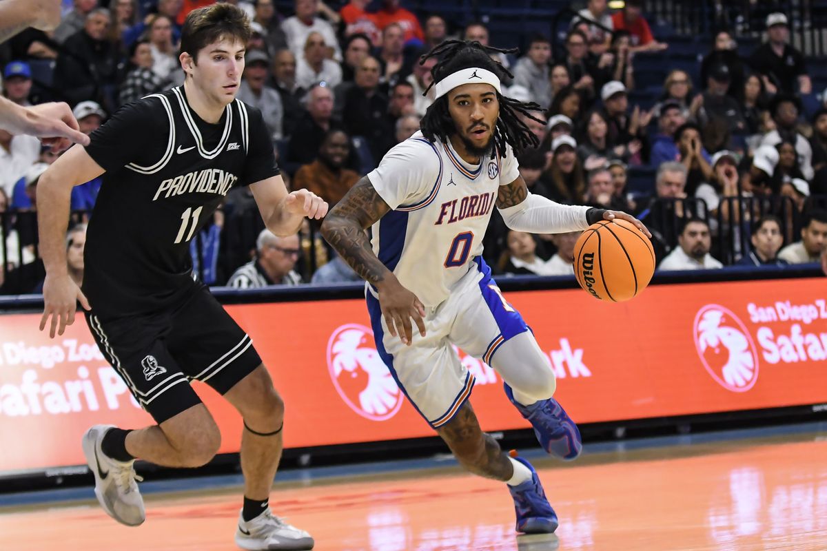 Florida guard Boogie Fland (0) dribbles past Providence guard Ryan Mela (11) during an NCAA basketball  game against Providence,Friday November 28, 2025 in  San Diego, California.