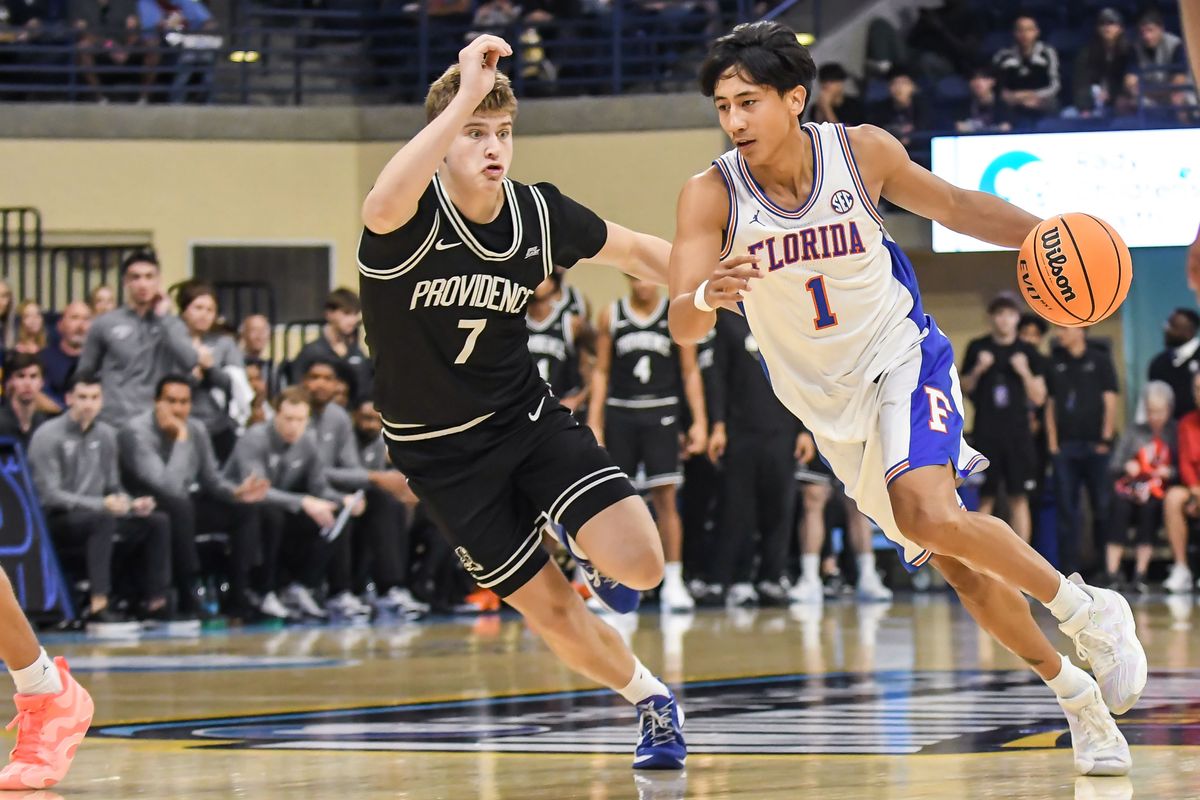Florida guard Xaivian Lee (1) dribbles past Providence guard Stefan Vaaks (7) during an NCAA basketball  game against Providence Friday November 28, 2025 in  San Diego, California.