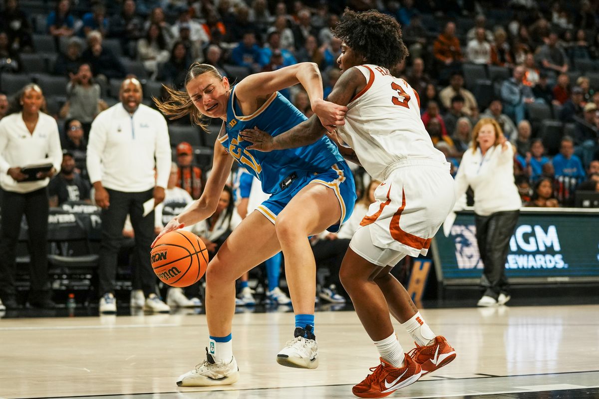 UCLA forward Justice Carlton (11) attempts to drive into the paint while guarded by Texas guard Rori Harmon (3) during second half of college basketball game against Texas on Wednesday, Nov. 26, 2025 during the Players Era tournament at Michelob Ultra Arena in Las Vegas.