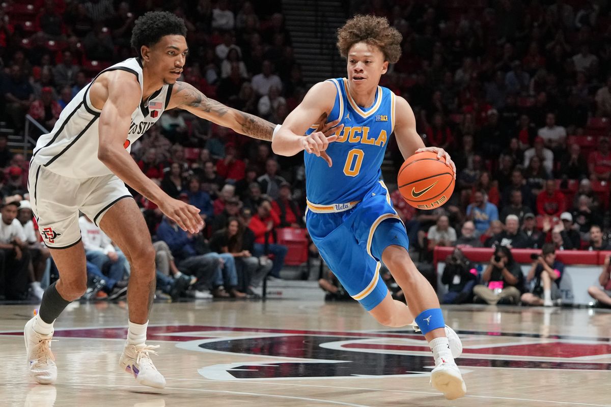 UCLA guard Trent Perry (0) dribbles past defenders during an NCAA basketball game against SDSU, Friday October 17, 2025 in San Diego, California.