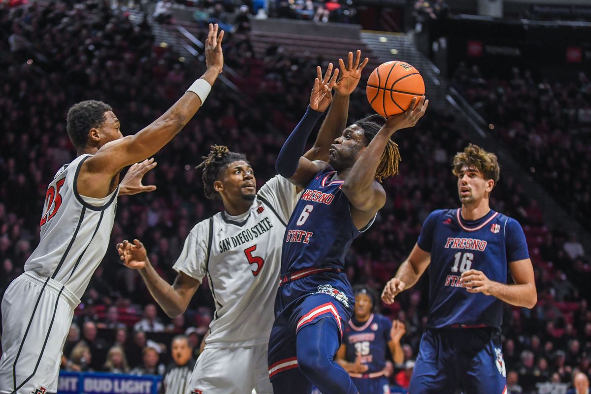 Fresno State  DJ Stickman (6) takes a contested shot against the defense of SDSU  Pharaoh Compton (5) during an NCAA men’s basketball game against  SDSU.  Saturday January 10, 2026 in  San Diego, California.