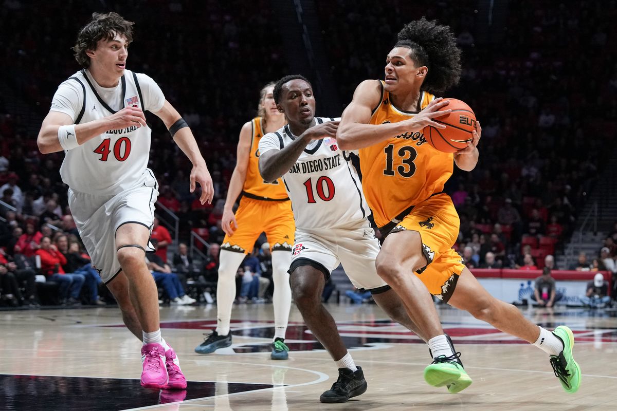 Wyoming guard Adam Harakow (13) dribbles the ball past defenders during an NCAA basketball game against SDSU, Tuesday February 03, 2026 in San Diego, California.