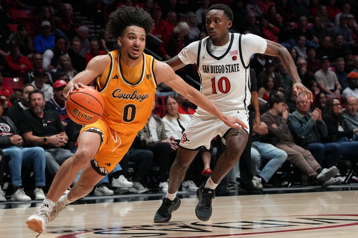 Wyoming guard Uriyah Rojas (0) dribbles the ball past defenders during an NCAA basketball game against SDSU, Tuesday February 03, 2026 in San Diego, California.