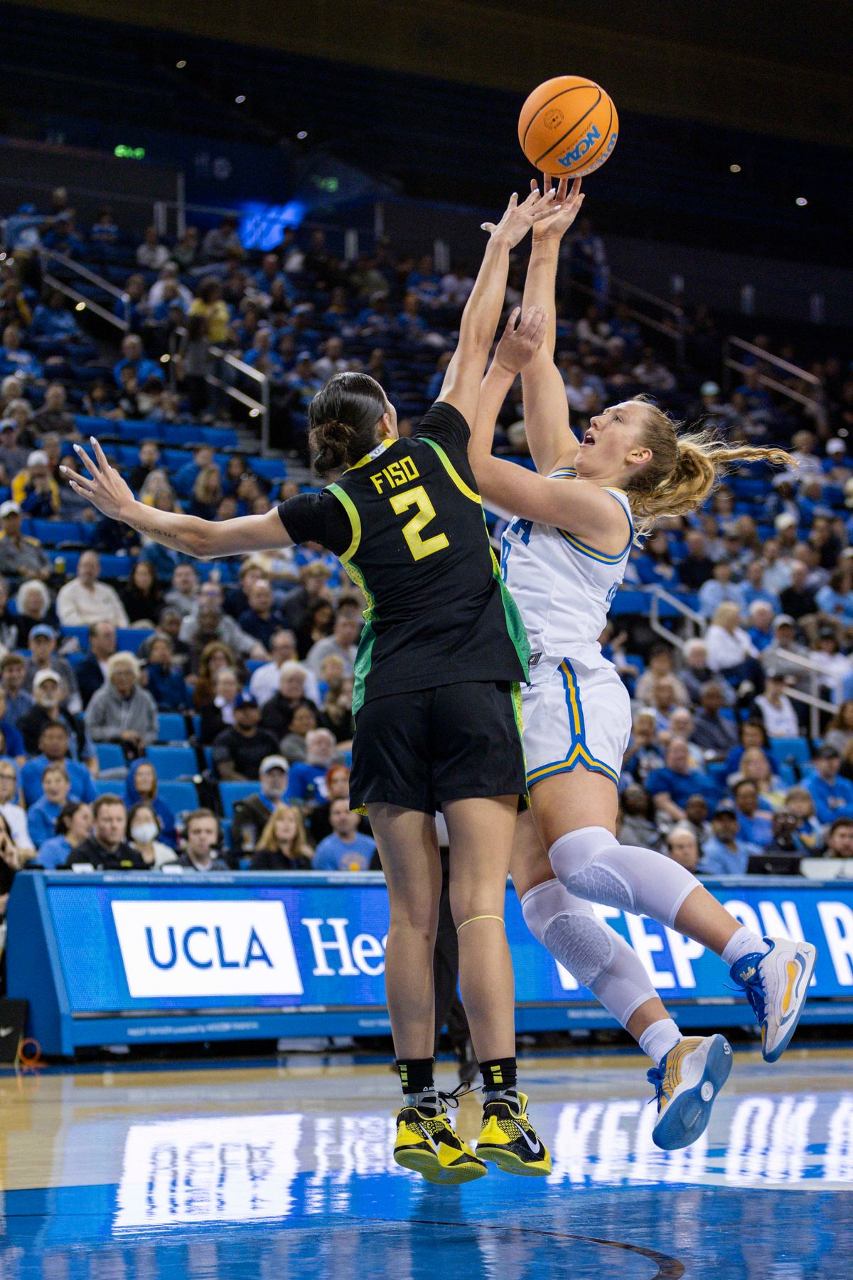 Guard Gianna Kneepkens #8 of the UCLA Bruins shoots the ball over guard Katie Fiso #2 of the Oregon Ducks during an NCAA basketball game, Sunday December 7, 2025 in Los Angeles, Calif. 