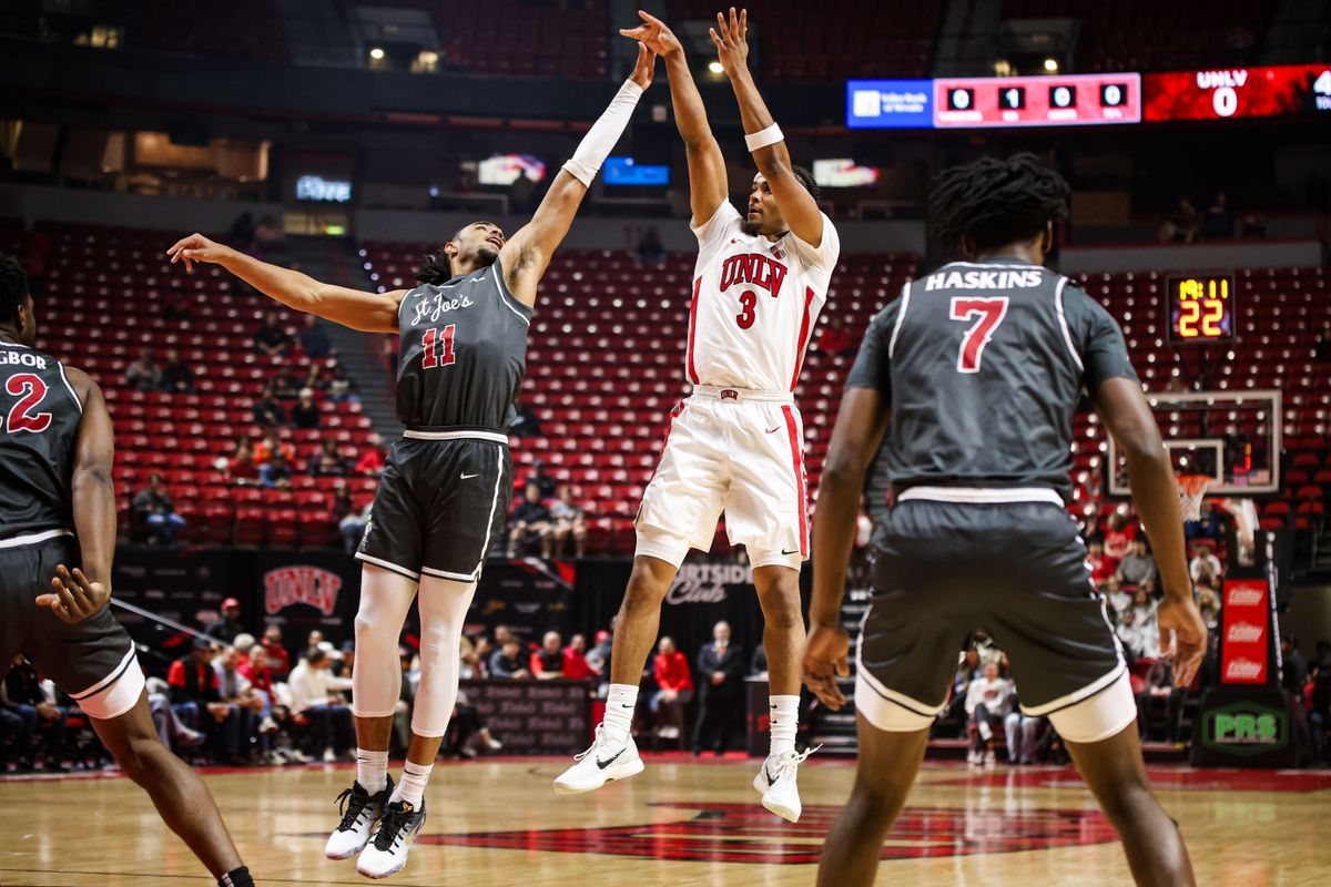 UNLV Runnin' Rebels G Howie Fleming Jr. (3) shoots a three-point shot over Saint Joseph's Hawks G Jaiden Glover-Toscano (11) during an NCAA basketball game on Thursday November 20, 2025, in Las Vegas, Nevada. 