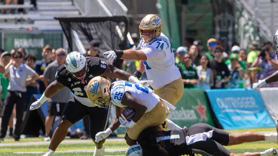 UCLA running back T.J. Harden (25) is tackled by Hawai'i defenders during the UCLA-Hawai'i game on Saturday, August 31, 2024.