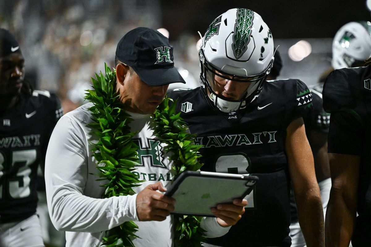University of Hawai'i Rainbow Warriors head coach Timmy Chang and quarterback Luke Weaver (2) review film during halftime of an NCAA football game against the Portland State Vikings, Saturday, September 13, 2025, in Honolulu, Hawai'i.