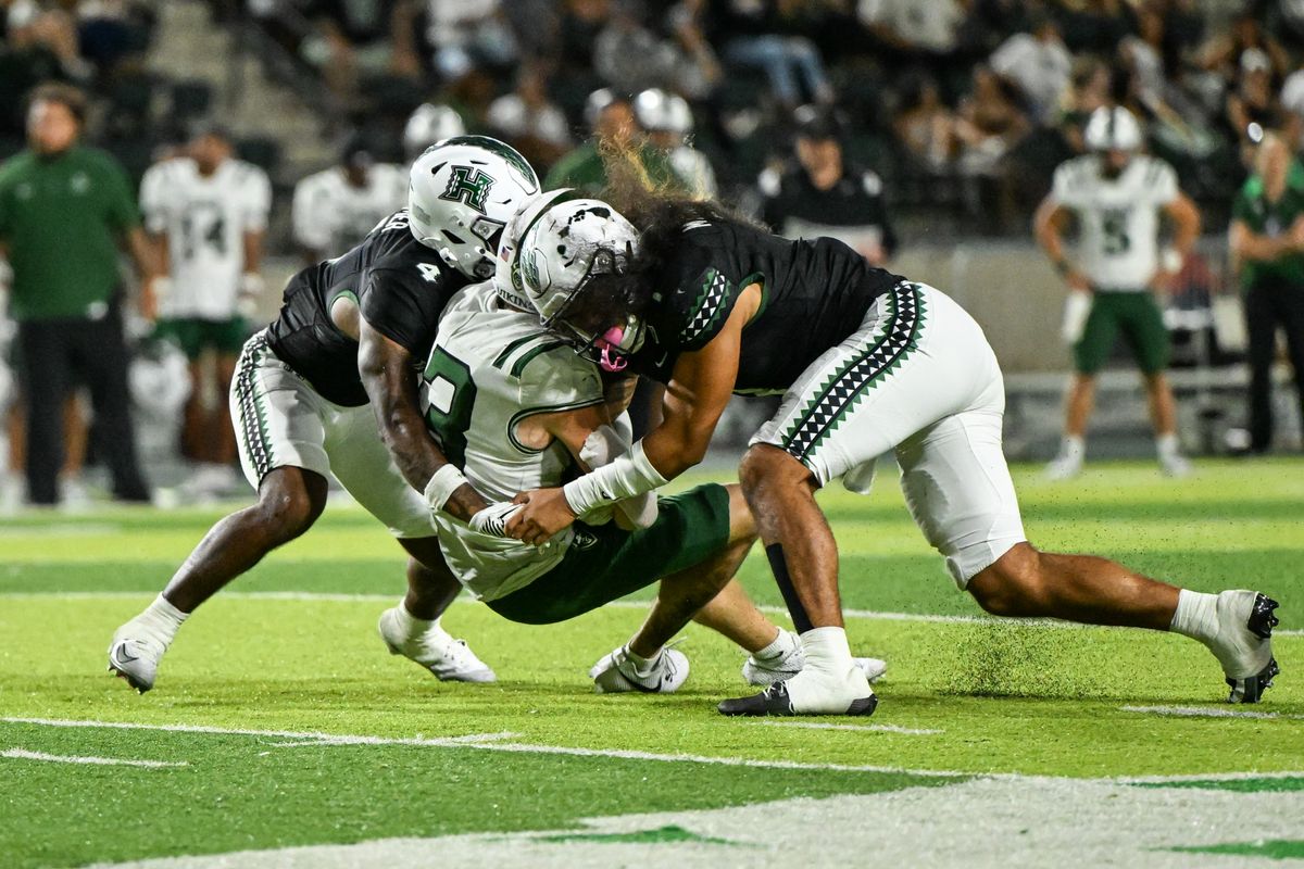 University of Hawai'i Rainbow Warriors defensive backs Peter Manuma (1) and Elijah Palmer (4) tackle Portland State Vikings wide receiver Eddy Schultz (13) during an NCAA football game, Saturday, September 13, 2025, in Honolulu, Hawai'i.