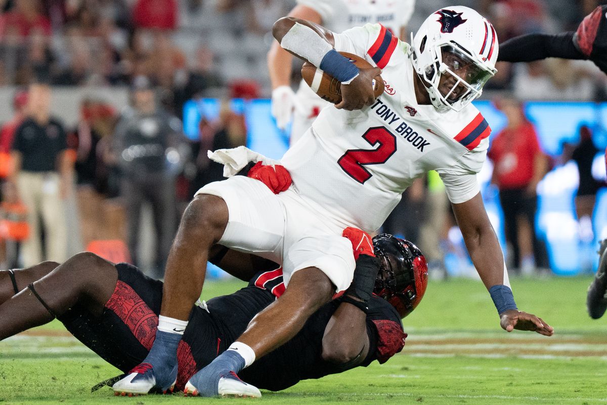 Stony Brook University quarterback Chris Zellous (2) gets tackled during an NCAA football game against San Diego State University, Thursday August 28, 2025 in San Diego, California.