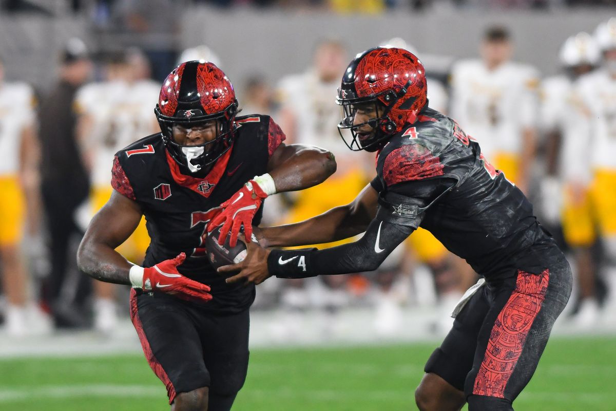 SDSU running back Lucky Sutton (7) takes the handoff from SDSU quarterback Jayden Denegal (4) during an NCAA football game against the Wyoming Cowboys Saturday November 1, 2025 in San Diego, California. SDSU running back Lucky Sutton (7) takes the handoff from SDSU quarterback Jayden Denegal (4) during an NCAA football game against the Wyoming Cowboys Saturday November 1, 2025 in San Diego, California.