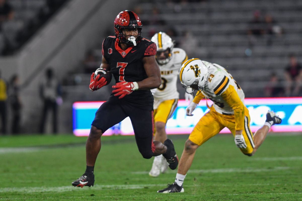 SDSU running back Lucky Sutton (7) runs by Wyoming safety Jones Thomas (23) on a touchdown run during an NCAA football game against the Wyoming Cowboys Saturday November 1, 2025 in San Diego, California. SDSU running back Lucky Sutton (7) runs by Wyoming safety Jones Thomas (23) on a touchdown run during an NCAA football game against the Wyoming Cowboys Saturday November 1, 2025 in San Diego, California.