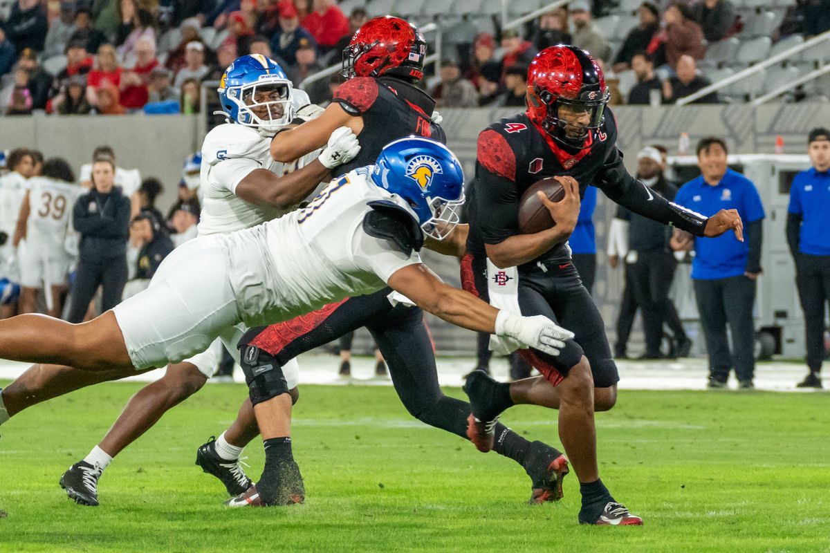 San Diego State quarterback Jayden Denegal (4) is tackled while running during an NCAA Football game between San Jose State and San Diego State, Saturday November 22, 2025 in San Diego, Calif.