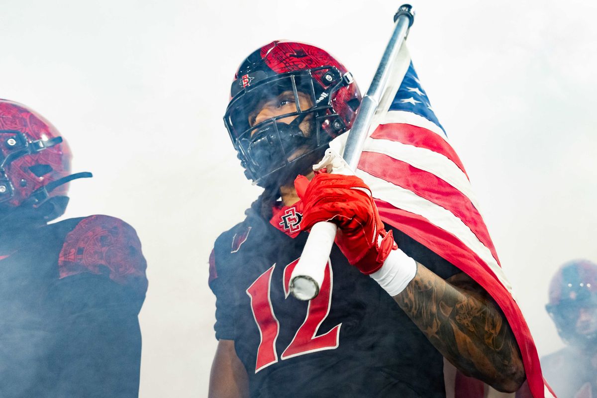 San Diego State linebacker Owen Chambliss (12) holds an American flag as his team is introduced during an NCAA Football game between San Jose State and San Diego State, Saturday November 22, 2025 in San Diego, Calif.