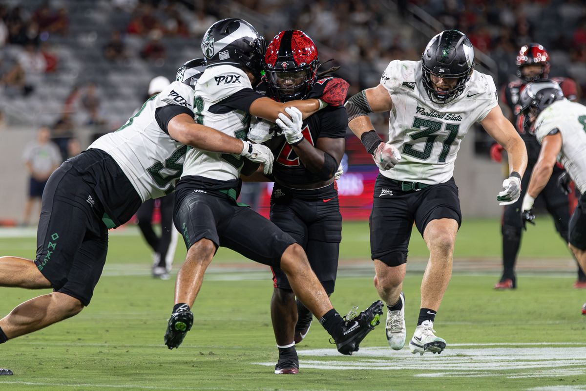 San Diego State running back Javion Kinnard (21) drags Portland State defenders, Saturday, Sept. 5, 2026, in San Diego.