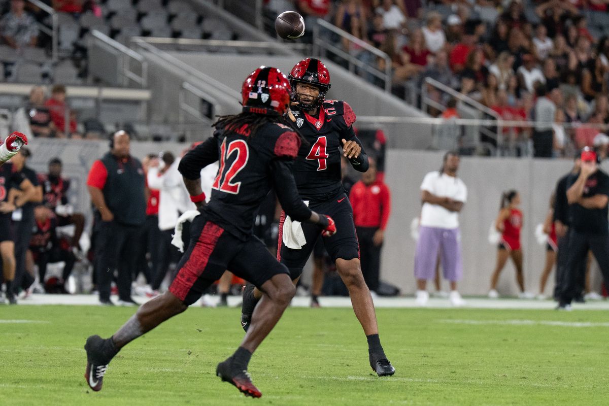 San Diego State University quarterback Jayden Denegal (4) throws the ball to San Diego State University wide receiver Jaylon Hawkins (12) during a PAC-12 football game against Fresno State, Saturday October 17, 2026 in San Diego, California. San Diego State University quarterback Jayden Denegal (4) throws the ball to San Diego State University wide receiver Jaylon Hawkins (12) during a PAC-12 football game against Fresno State, Saturday October 17, 2026 in San Diego, California.
