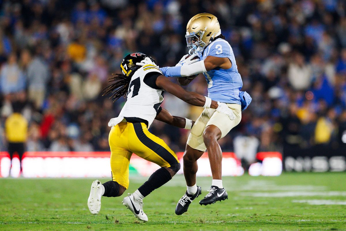 Kwazi Gilmer #3 of the UCLA Bruins is tackled by Jermari Harris #27 of the Iowa Hawkeyes during the first half game against Iowa Hawkeyes at Rose Bowl Stadium on November 8, 2024 in Pasadena, California.