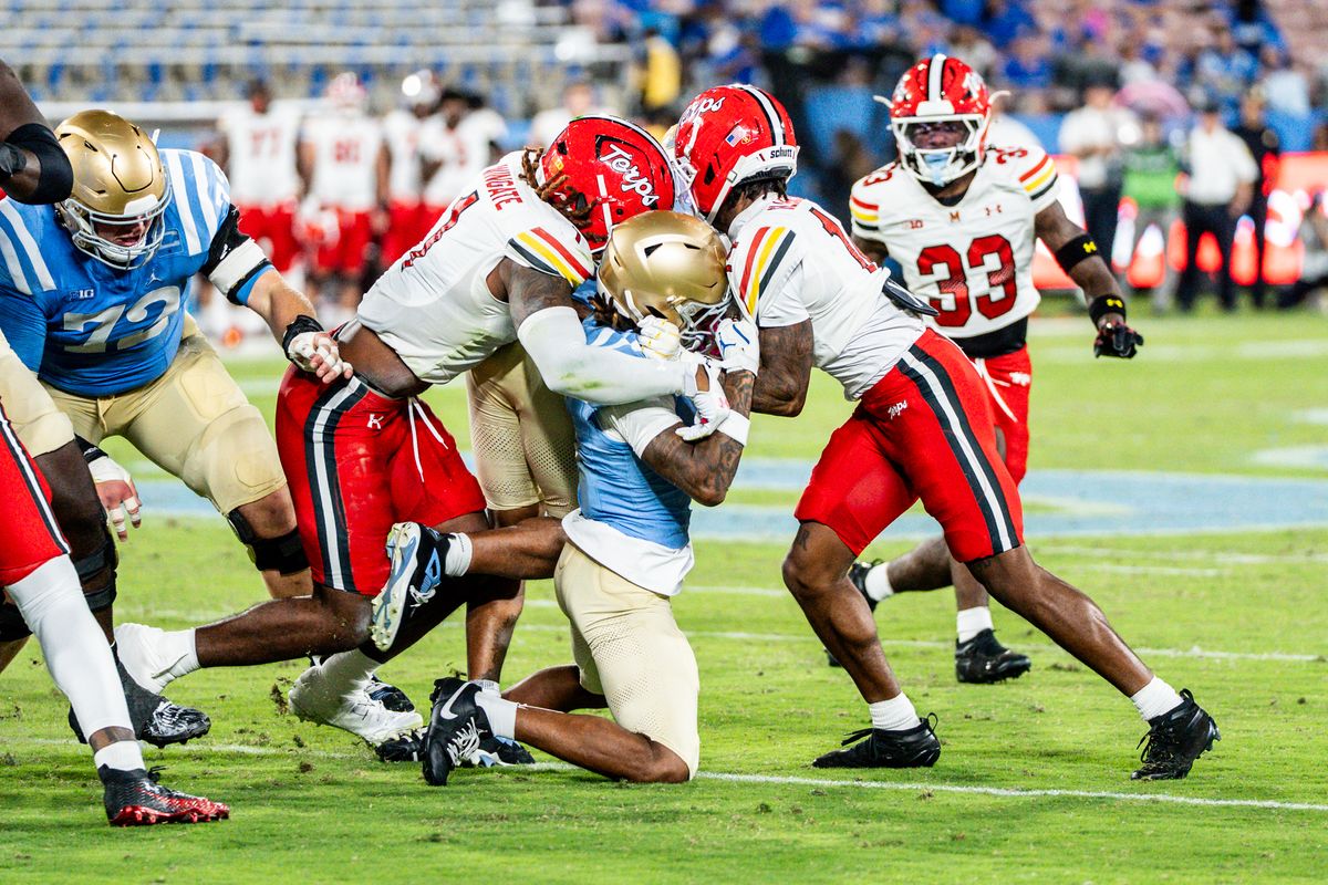 #6 Anthony Woods of UCLA gets slammed between two defenders during an NCAA football game against Maryland Terrapinson October 18, 2025 in Pasadena, CA.