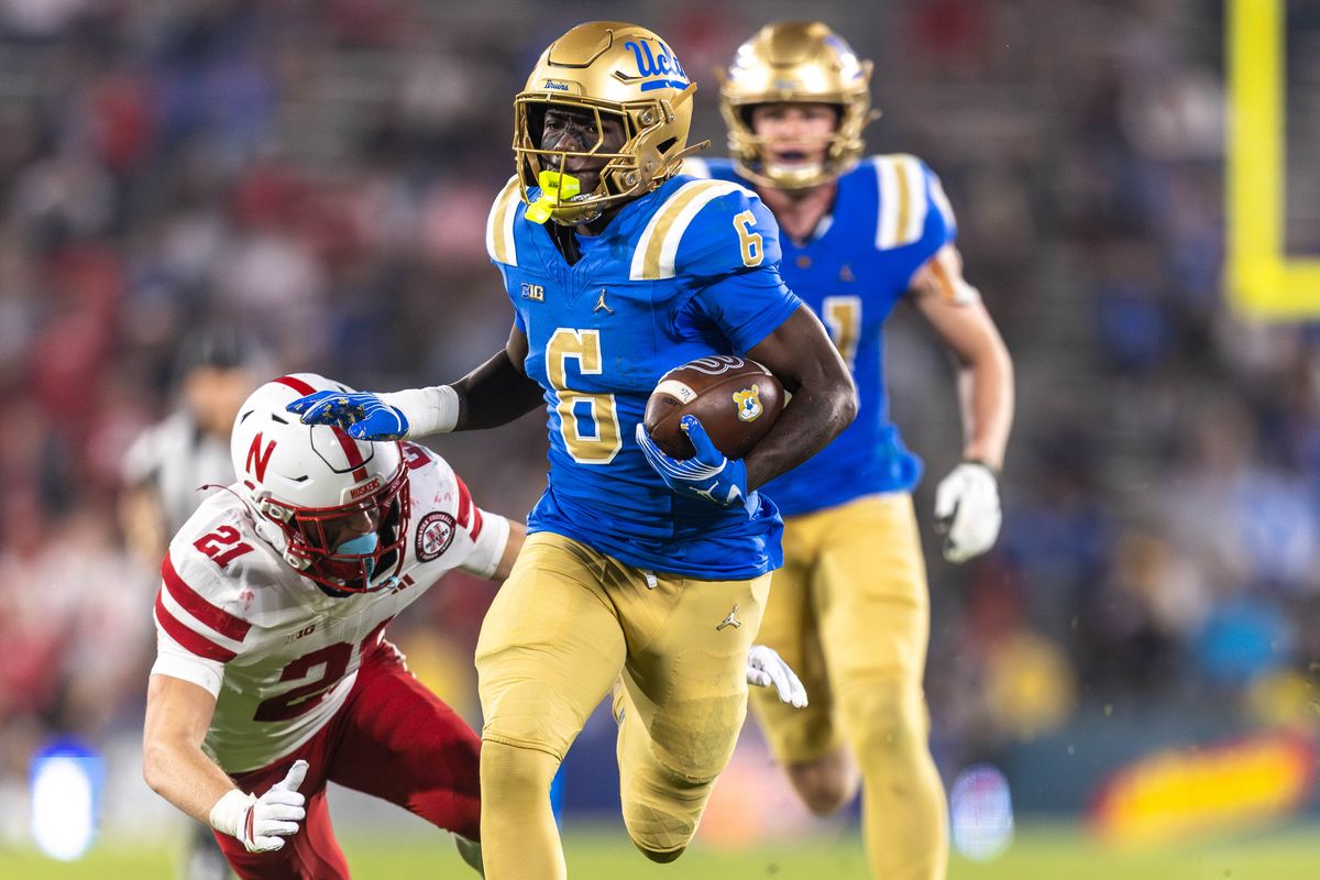 UCLA Bruins running back Anthony Woods (6) runs the ball while shoving Nebraska Cornhuskers defensive back Rex Guthrie (21) during the game against Nebraska Cornhuskers at Rose Bowl Stadium on November 8, 2025 in Pasadena, California. 