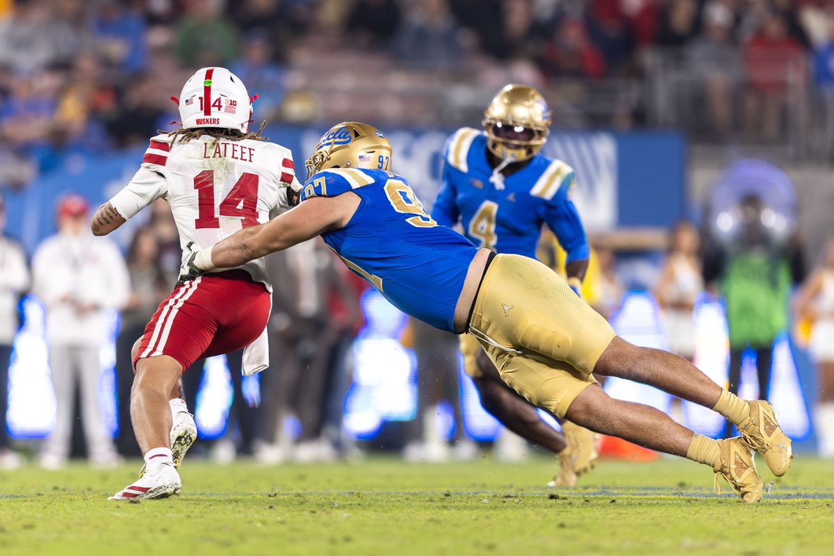 UCLA Bruins defensive lineman Jacob Busic (97) attempts to sack Nebraska Cornhuskers quarterback TJ Lateef (14) during the game against Nebraska Cornhuskers at Rose Bowl Stadium on November 8, 2025 in Pasadena, California. 
