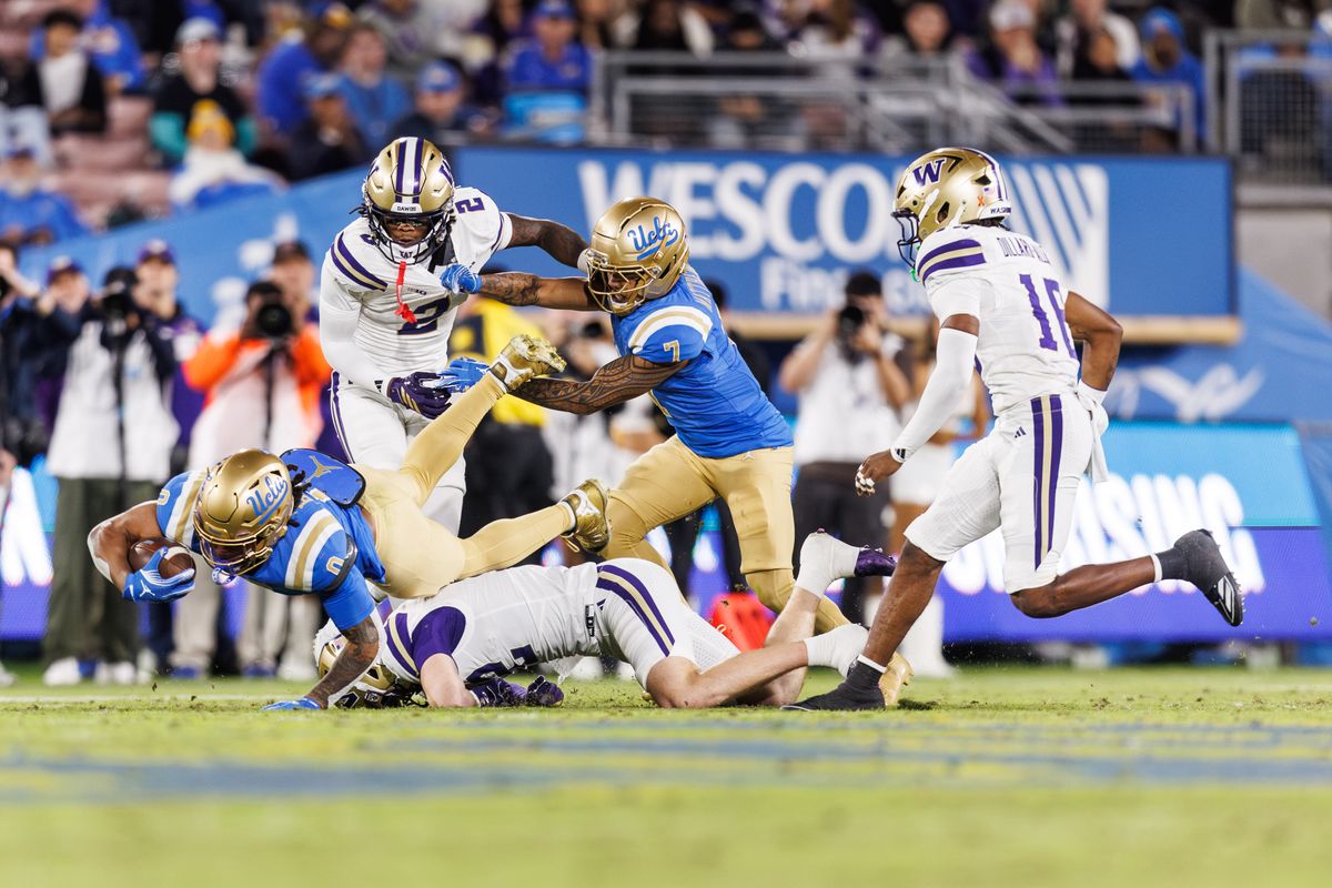 UCLA Bruins running back Jalen Berger (0) dives while getting tackled during the game against Washington Huskies at Rose Bowl Stadium on November 22, 2025 in Pasadena, California. 