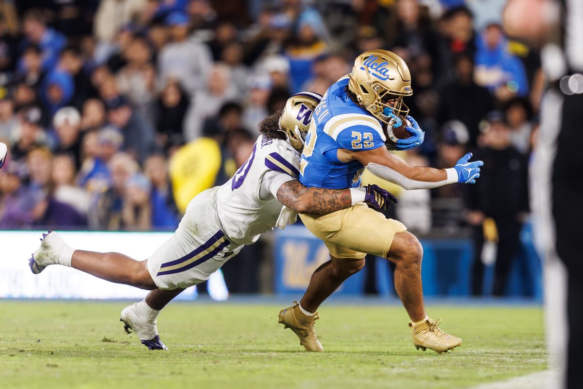 UCLA Bruins running back Anthony Frias II (22) runs the ball while getting tackled during the game against Washington Huskies at Rose Bowl Stadium on November 22, 2025 in Pasadena, California. 