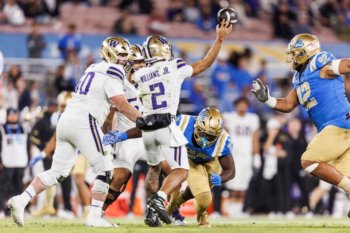UCLA Bruins defensive lineman Cole Cogshell (24) goes for the sack on Washington Huskies quarterback Demond Williams Jr. (2) during the game against Washington Huskies at Rose Bowl Stadium on November 22, 2025 in Pasadena, California. 