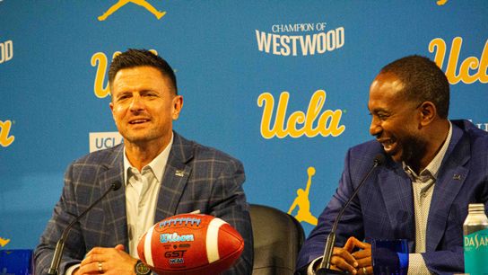 UCLA atheltic director Martin Jarmond laughs while new football head coach Bob Chesney tells a story at the introductory press conference for Bob Chesney at Luskin Conference Center Tuesday, December 9, 2025 in Los Angeles.