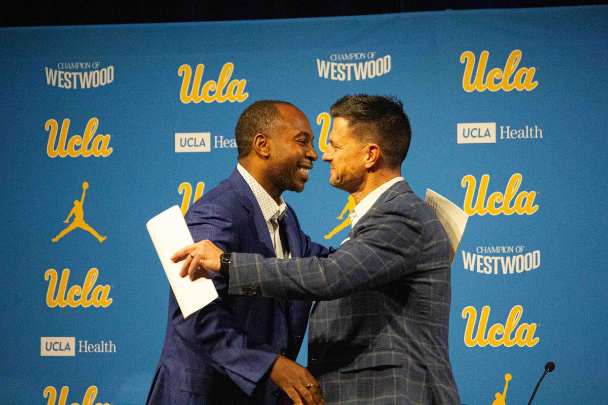 UCLA athletic director Martin Jarmond embraces new UCLA football head coach Bob Chesney at the introductory press conference for Bob Chesney at Luskin Conference Center Tuesday, December 9, 2025 in Los Angeles.