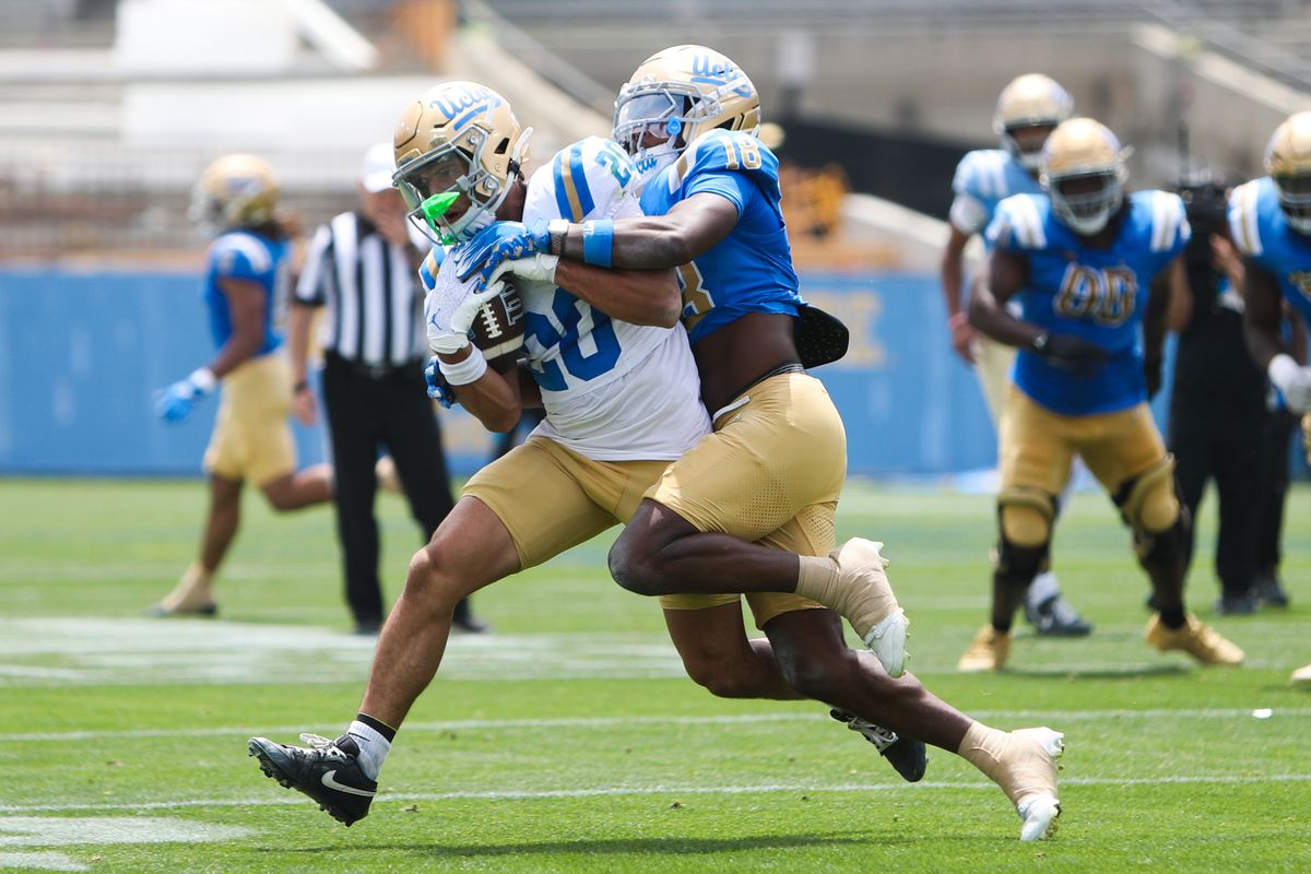 Shane Rosenthal #20 is tackled by Osiris Gilbert #18 during the UCLA Football Spring Showcase at Rose Bowl Stadium on May 2, 2026 in Pasadena, California.