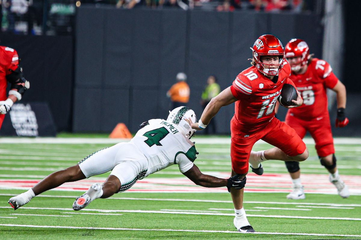 UNLV Rebels QB Anthony Colandrea (10) evades a tackle from Hawai'i Rainbow Warriors DB Elijah Palmer (4) during a college football game on Friday November 21, 2025, in Las Vegas, Nevada. 