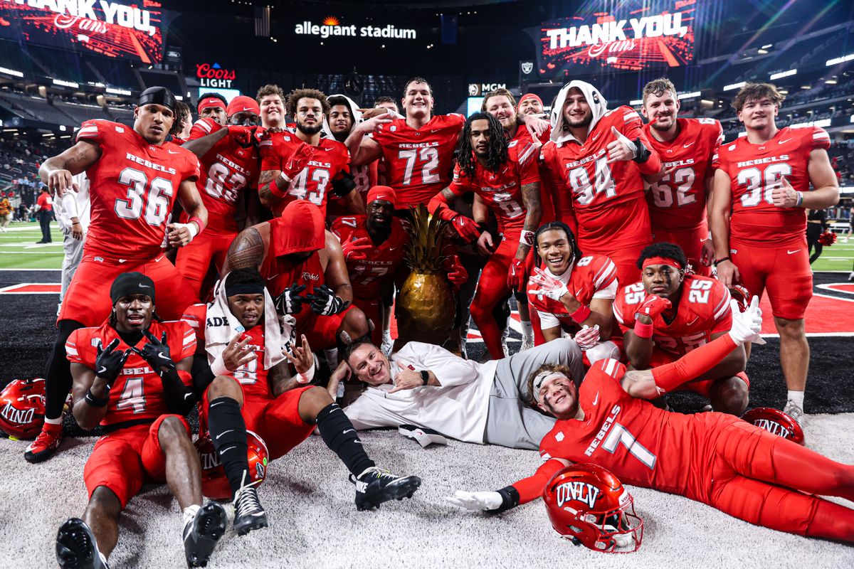 UNLV Rebels HC Dan Mullen poses with the Island Showdown Trophy with his team after defeating the Hawai'i Rainbow Warriors in the 9th Island Classic on Friday November 21, 2025, in Las Vegas, Nevada. 