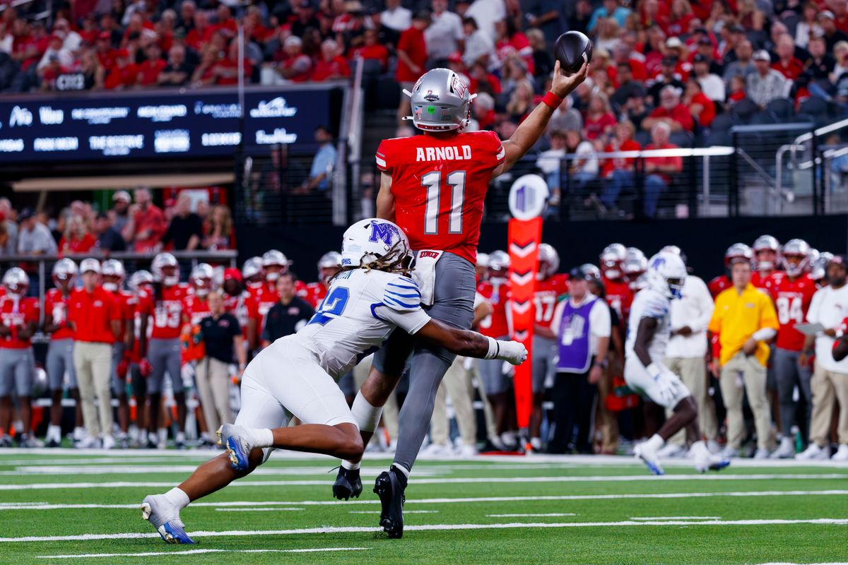 UNLV Football quarterback Jackson Arnold throws the ball while being tackled during a non-conference college football game against the Memphis Tigers on Saturday, August 29, 2026, at Allegiant Stadium in Las Vegas, NV. UNLV Football quarterback Jackson Arnold throws the ball while being tackled during a non-conference college football game against the Memphis Tigers on Saturday, August 29, 2026, at Allegiant Stadium in Las Vegas, NV.