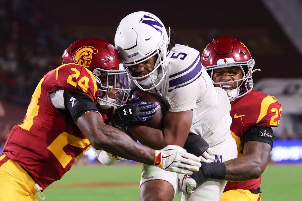 Safety Christian Pierce #24 and linebacker Desman Stephens II #23 of the USC Trojans wrap up running back Caleb Komolafe #5 of the Northwestern Wildcats during an NCAA football game, Friday November 7, 2025 in Los Angeles, Calif. Safety Christian Pierce #24 and linebacker Desman Stephens II #23 of the USC Trojans wrap up running back Caleb Komolafe #5 of the Northwestern Wildcats during an NCAA football game, Friday November 7, 2025 in Los Angeles, Calif.